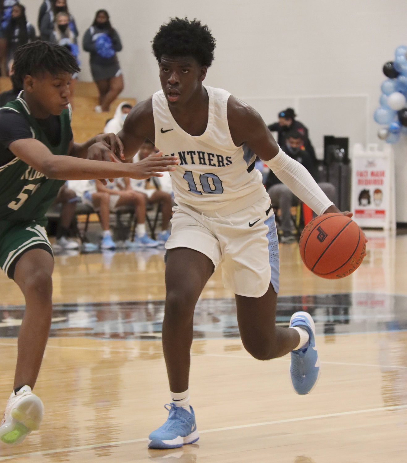 Paetow junior forward Idy Igbaroola (10) handles the ball against defensive pressure during the Panthers’ game against Bryan Rudder on Saturday, Feb. 6, at Paetow High.