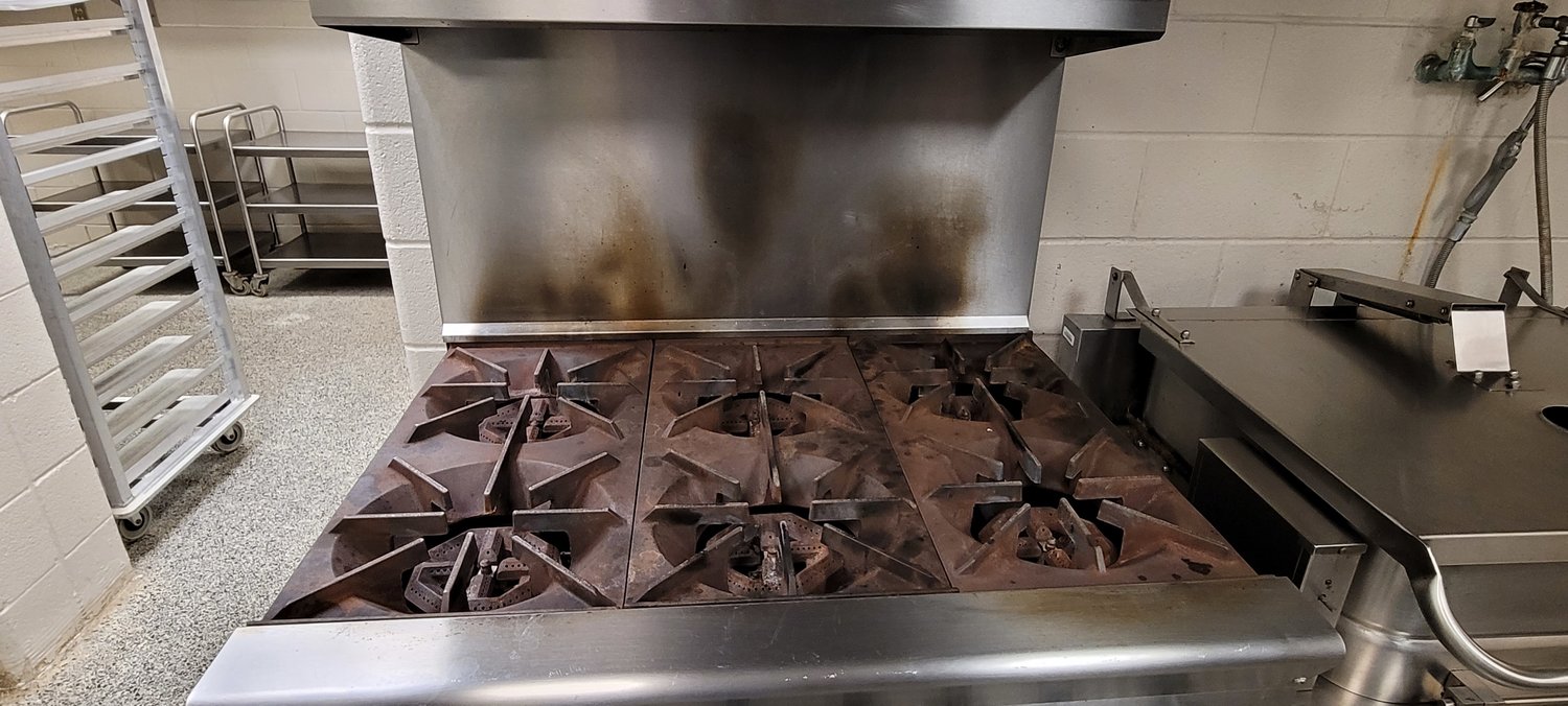Aging equipment in the Royal STEM Academy's kitchen cause safety concerns and increases problems for staff. This stove is rusty along all of its burners, the chillers that store food does not seal properly and the dishwasher is broken - forcing cooks to wash all of the dishes by hand rather than with an automated process.
