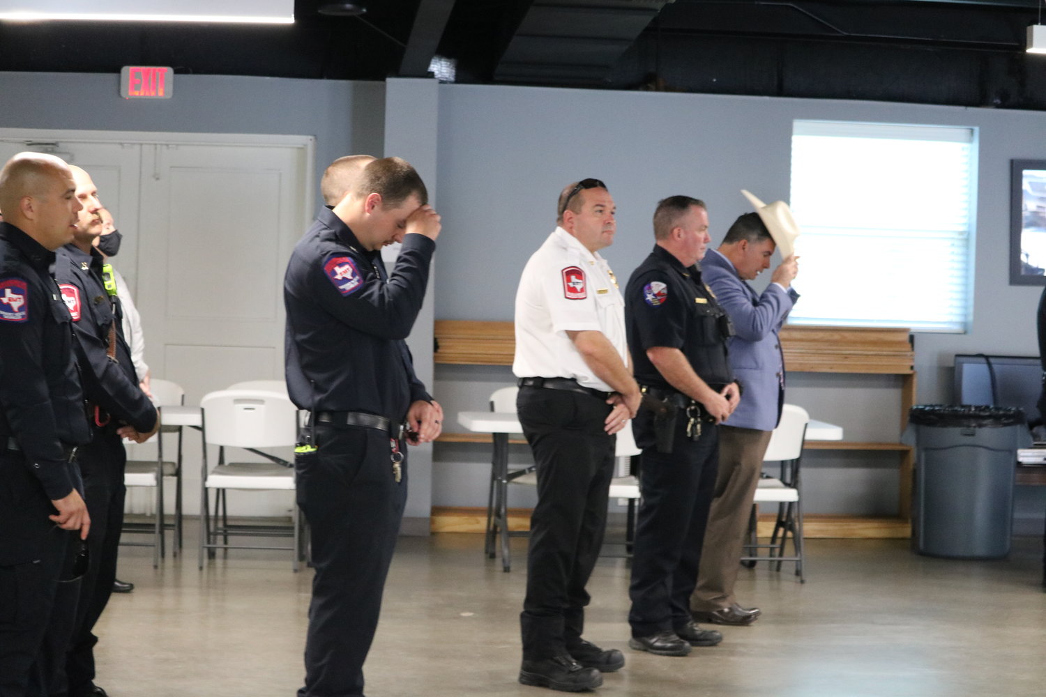 Policemen stand, and Katy Police Chief Noe Diaz removes his hat for a prayer during Saturday's 9/11 event at the Katy VFW.