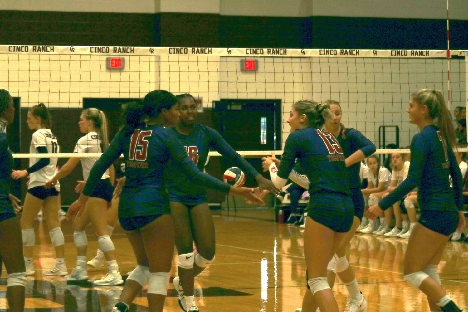 Tompkins celebrates winning a point during a match against Cinco Ranch at the Cinco Ranch gym on Tuesday.