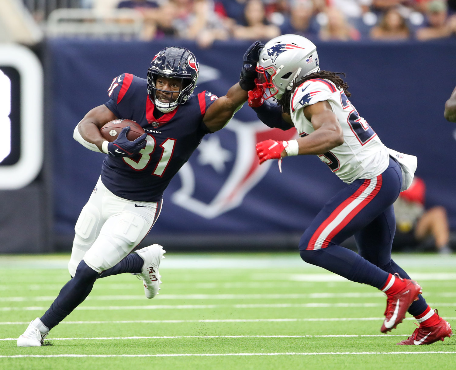 Houston Texans running back David Johnson (31) delivers a stiff arm to New England Patriots defensive back Kyle Dugger (23) on a carry during an NFL game between Houston and New England on October 10, 2021 in Houston, Texas. The Patriots won 25-22.