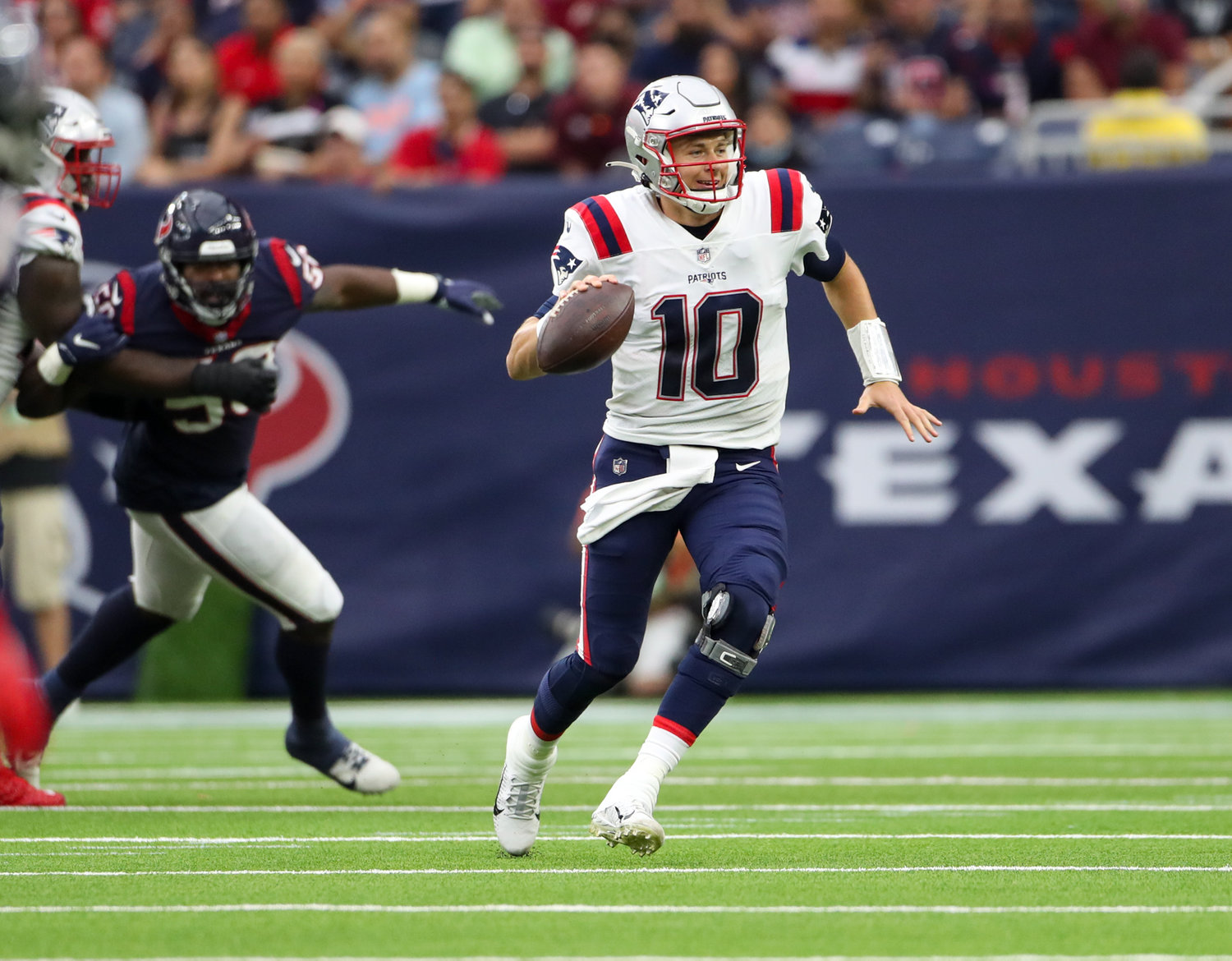 New England Patriots quarterback Mac Jones (10) escapes pressure and scrambles out of the backfield during an NFL game between Houston and New England on October 10, 2021 in Houston, Texas. The Patriots won 25-22.