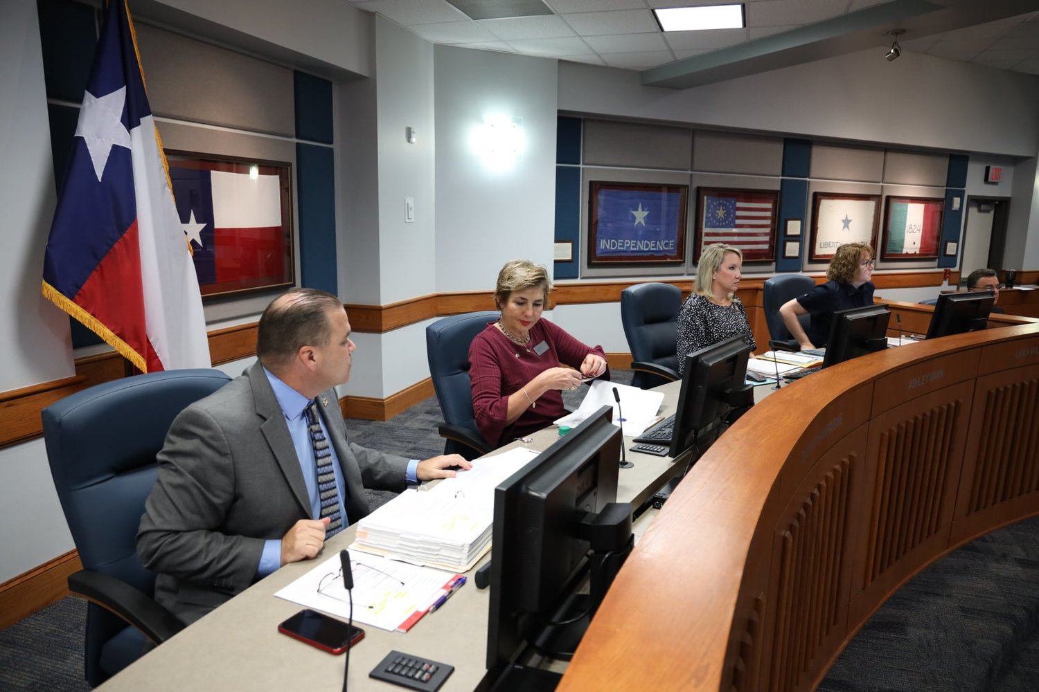 Dawn Champagne (second from left in maroon) speaks with Katy ISD Superintendent Ken Gregorski (far left) during a recent Katy ISD Board of Trustees meeting.
