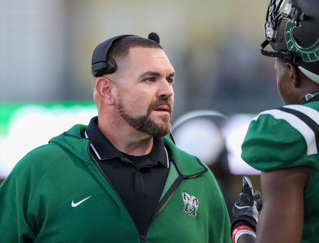 Mayde Creek Rams head coach J. Jensen talks with a player on the sideline during a high school football game between Mayde Creek and Seven Lakes on October 29, 2021 in Katy, Texas. Seven Lakes won, 50-10.