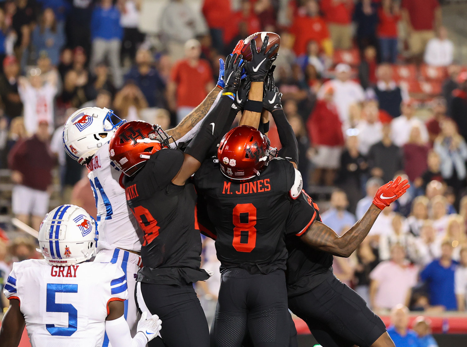 Houston Cougars defenders grab and knock down an attempted Hail Mary pass by SMU as Houston holds on to win 44-37 in an NCAA football game on October 30, 2021 in Houston, Texas.