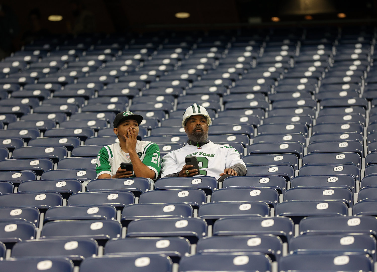 A pair of New York Jets fans arrive early for an NFL game between the Houston Texans and the New York Jets on November 28, 2021 in Houston, Texas.