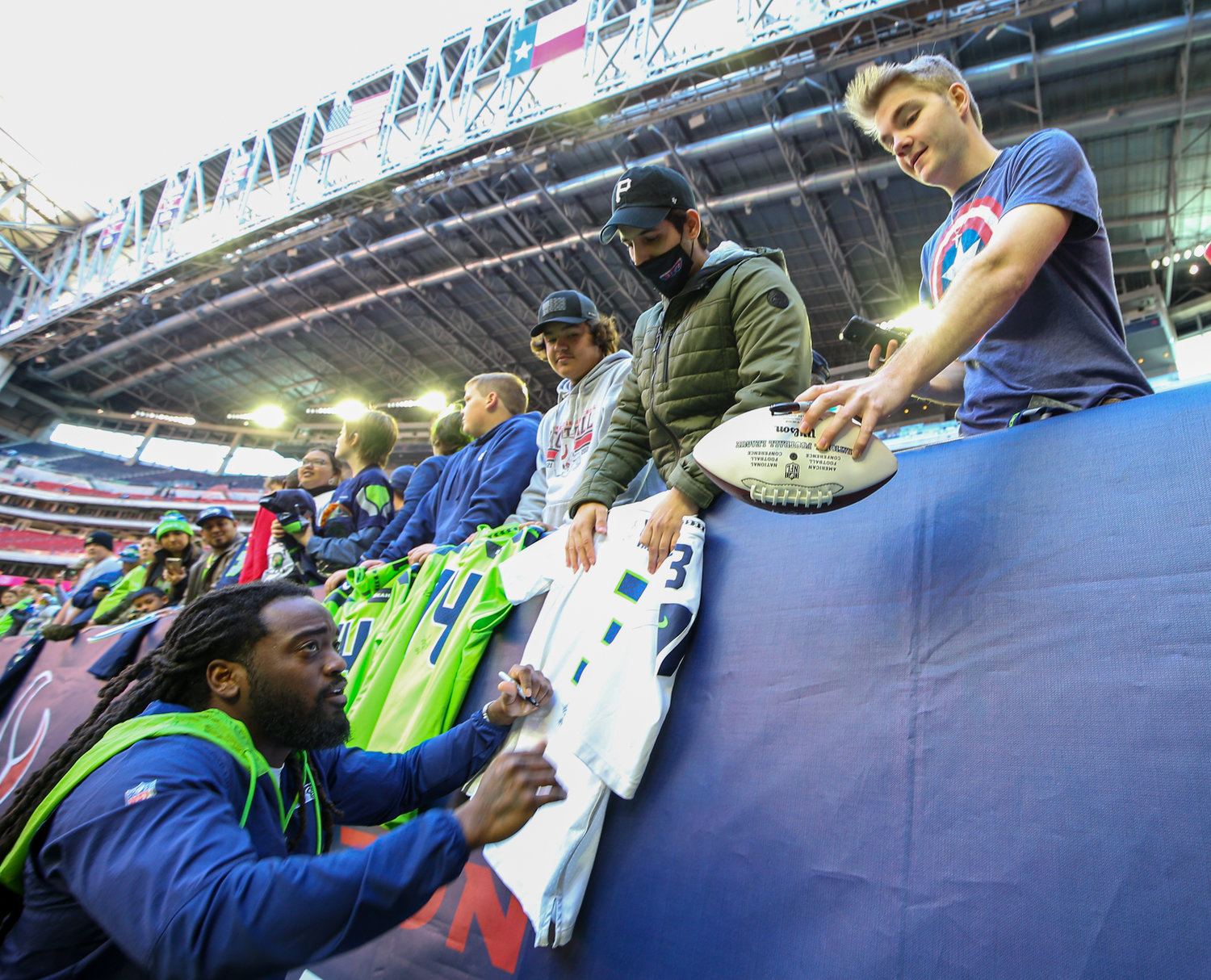 Seattle running back Alex Collins (41) signs souvenirs for Seahawks fans before the start of an NFL game between the Seahawks and the Texans on December 12, 2021 in Houston, Texas.
