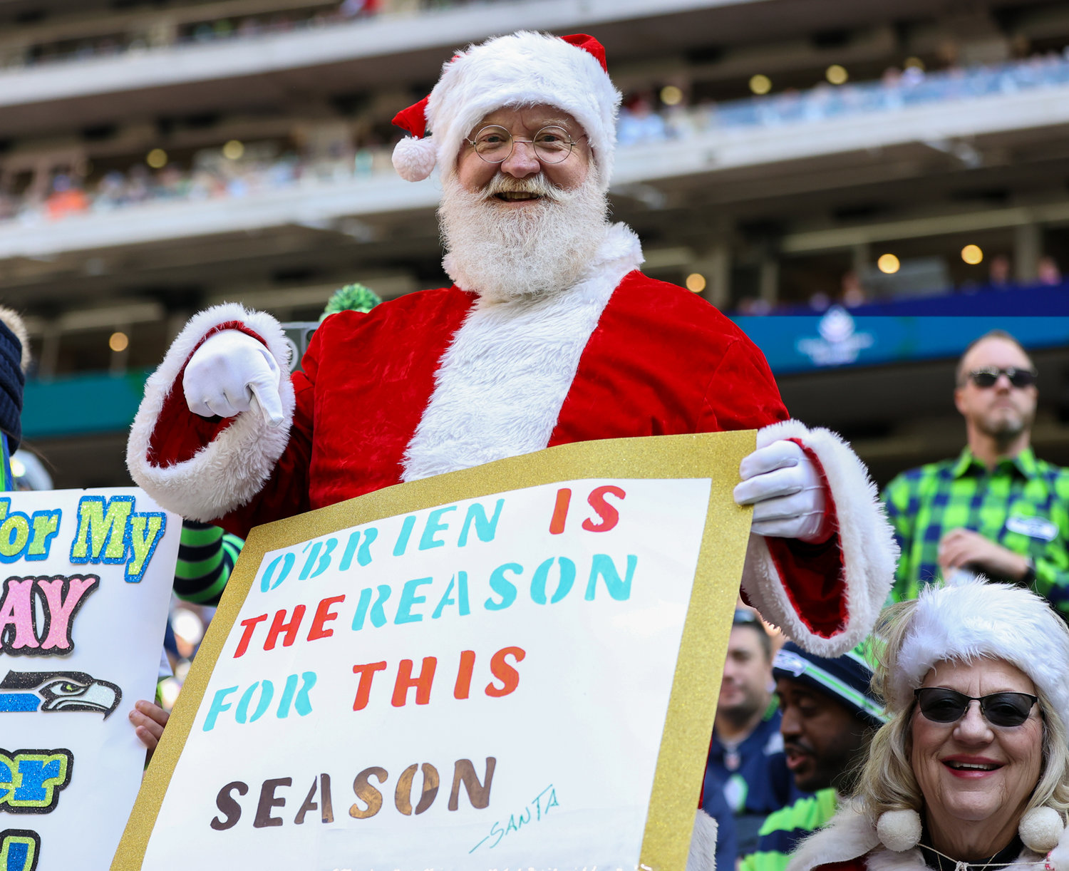 A Houston Texans fan dressed as Santa Claus holds a sign during the first half of an NFL game between the Seahawks and the Texans on December 12, 2021 in Houston, Texas.