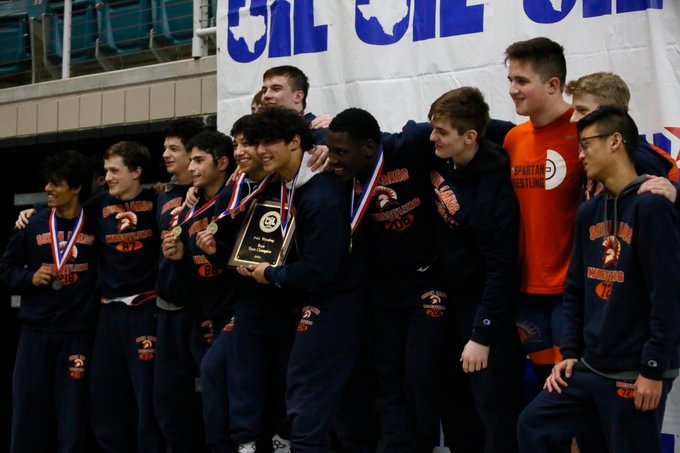 The Seven Lakes boys wrestling team celebrates after winning the team title at the District 9-6A meet