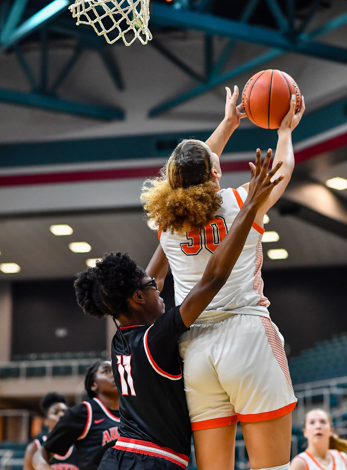 Katy Tx. Feb 22, 2022:  Seven Lakes Justice Carlton #30 gets the shot off over her shoulder scoring for the Spartans during the Regional Quarterfinal playoff game, Seven Lakes vs Fort Bend Austin at the Merrell Center. (Photo by Mark Goodman / Katy Times)