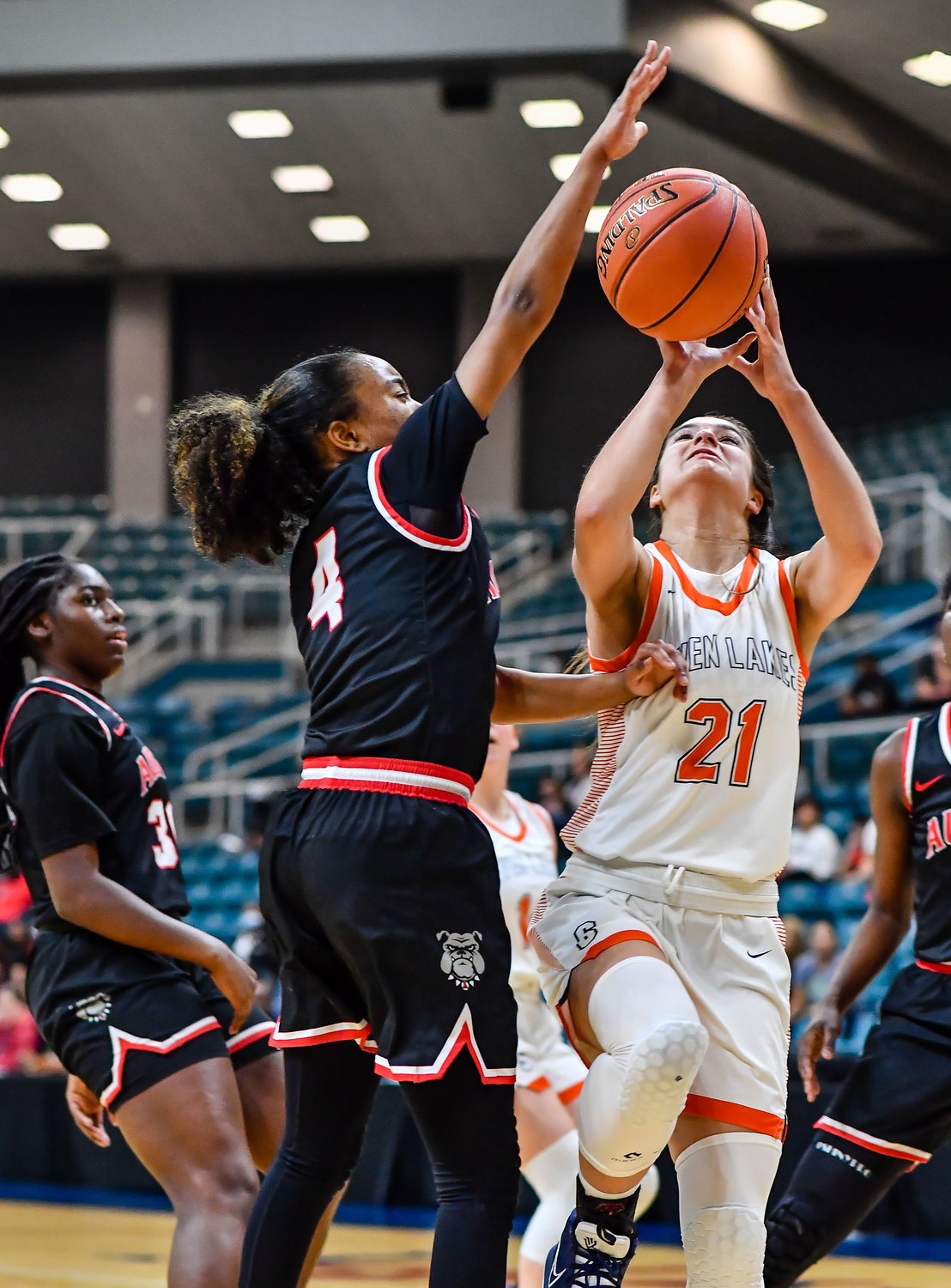 Katy Tx. Feb 22, 2022:  Seven Lakes Aliyah Atiqi #21 drives  up to the basket guarded by Fort Bend Austins Aminah Dixon #4 during the Regional Quarterfinal playoff game, Seven Lakes vs Fort Bend Austin at the Merrell Center. (Photo by Mark Goodman / Katy Times)