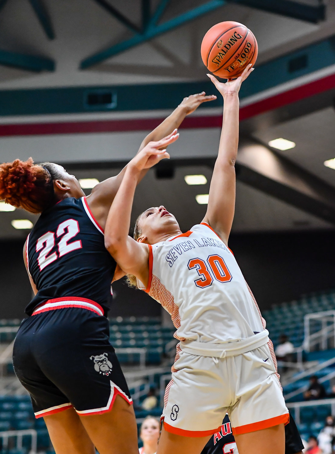 Katy Tx. Feb 22, 2022:   Seven Lakes Justice Carlton #30 avoids the block by Fort Bend Austins Gabrielle Johnson #22 scoring for the Spartans during the Regional Quarterfinal playoff game, Seven Lakes vs Fort Bend Austin at the Merrell Center. (Photo by Mark Goodman / Katy Times)