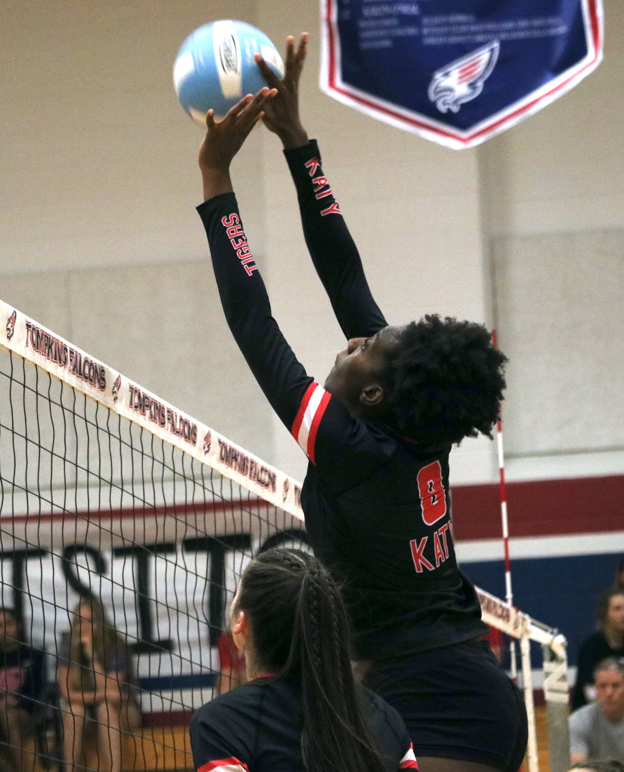 Katy’s Tarcy Mayah tips a ball over the net during Tuesday’s match between Tompkins and Katy at the Tompkins gym.