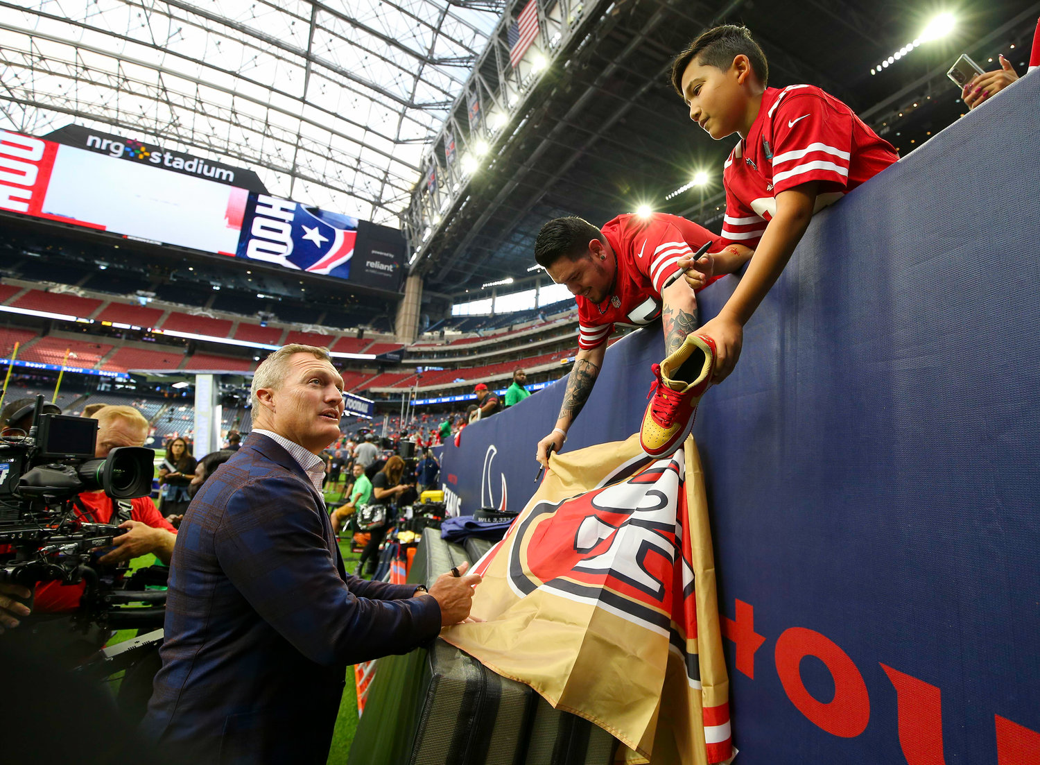 San Francisco 49ers General Manager John Lynch signs autographs before the start of an NFL preseason game between the Texans and the 49ers in Houston, Texas, on August 25, 2022.