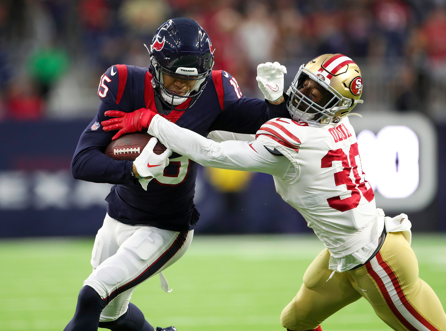 Houston Texans wide receiver Chris Moore (15) fends off a tackle attempt by San Francisco 49ers safety George Odum (30) during an NFL preseason game between the Texans and the 49ers in Houston, Texas, on August 25, 2022.