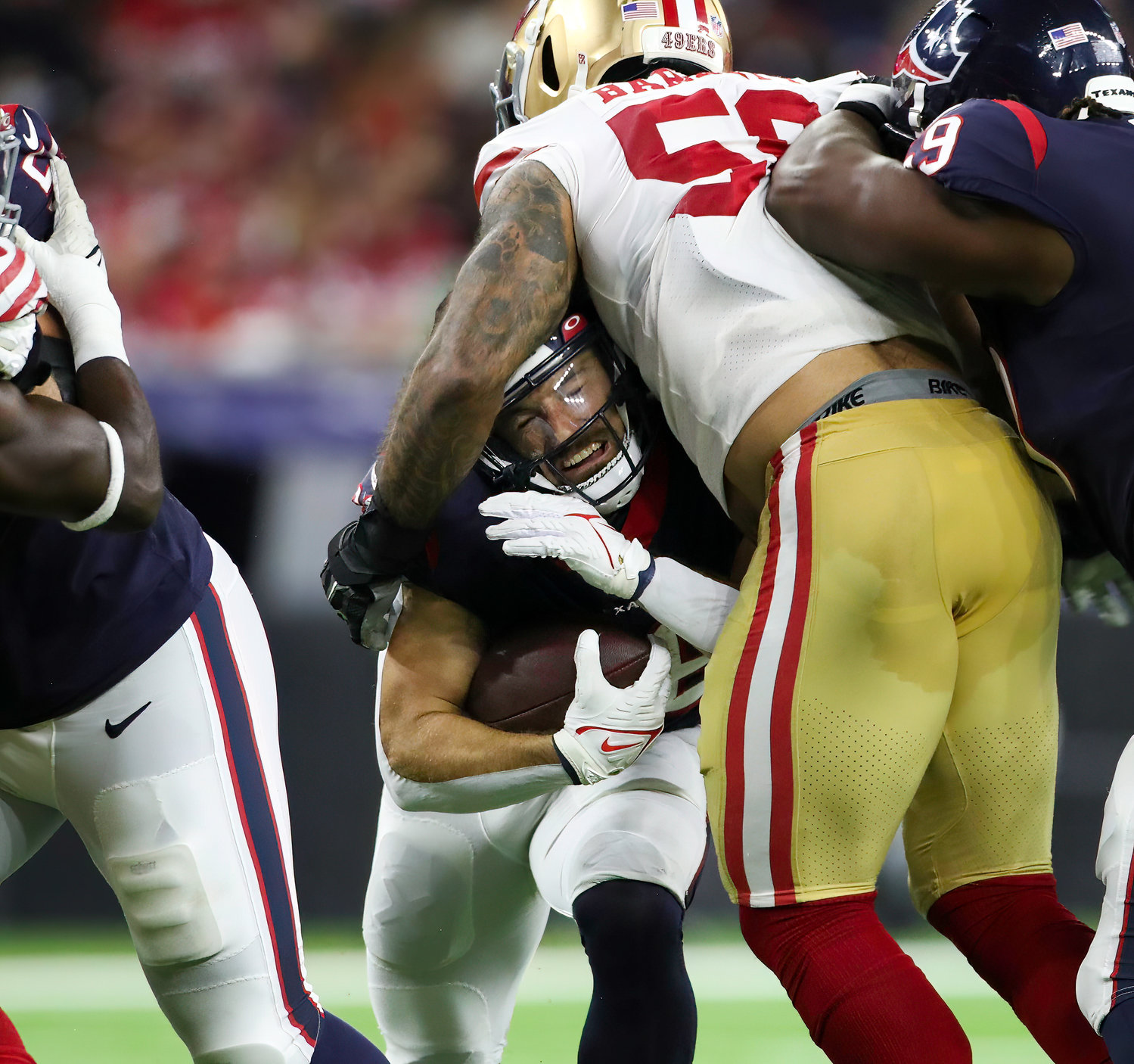 San Francisco 49ers defensive end Alex Barrett (58) wraps up Houston Texans running back Rex Burkhead (28) for a tackle during an NFL preseason game between the Texans and the 49ers in Houston, Texas, on August 25, 2022.