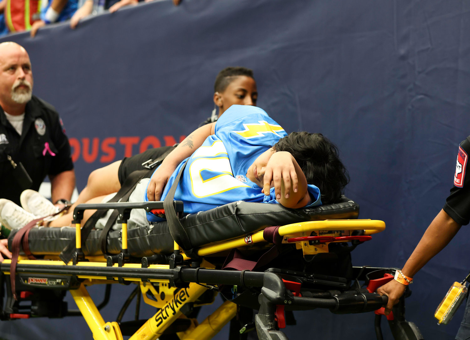 A fan experiencing a medical emergency is stretchered off the field after being lowered from the stands during an NFL game between the Texans and the Chargers on Oct. 2, 2022 in Houston. The Chargers won 34-24.