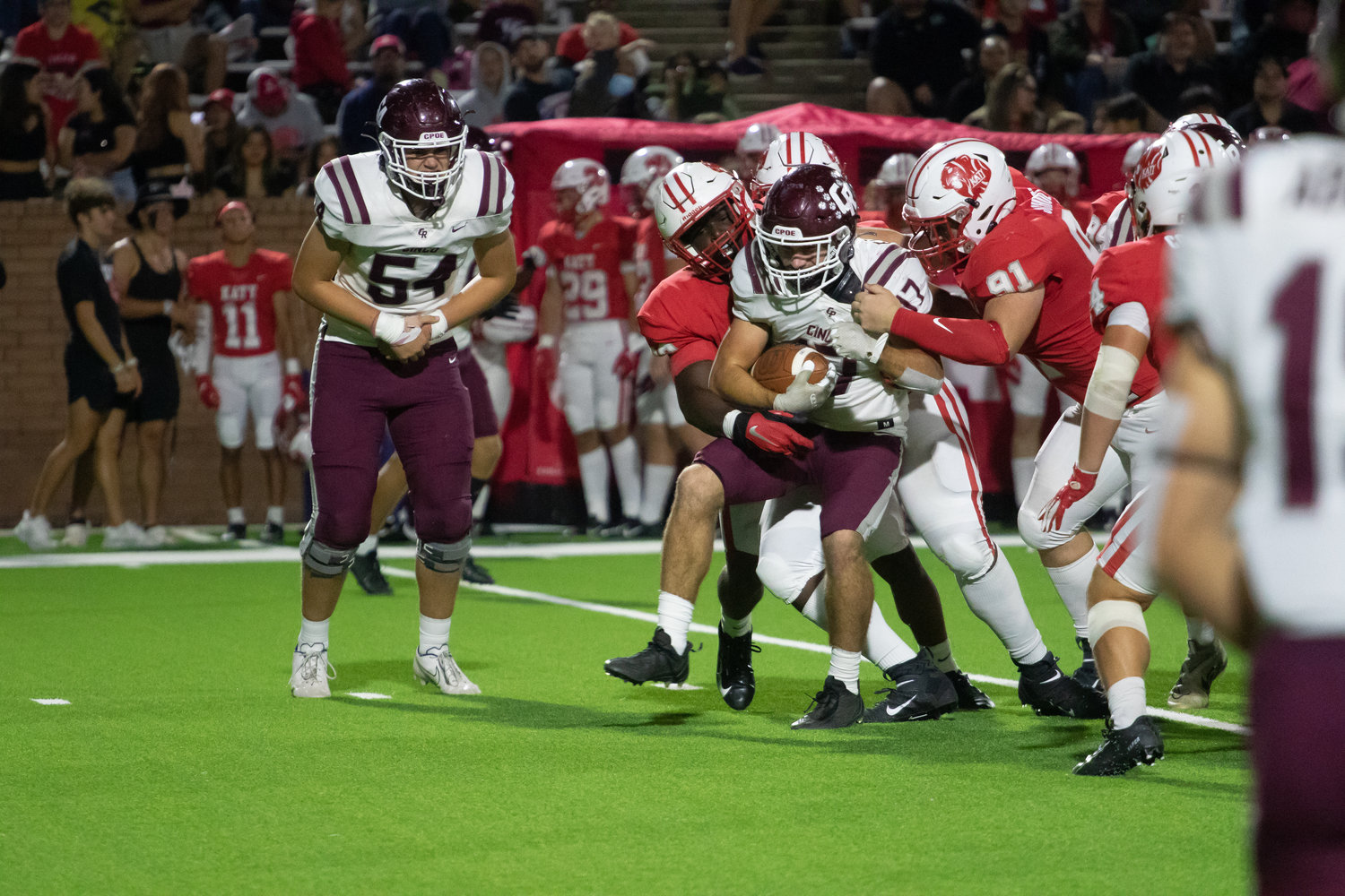 Cinco Ranch's Eric Eckstrom is wrapped up by Katy defenders during Friday's game between Katy and Cinco Ranch at Rhodes Stadium.