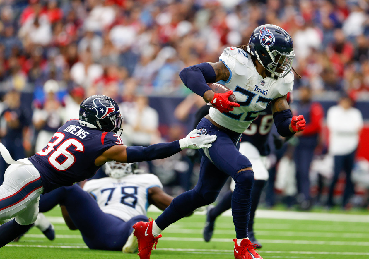Titans running back Derrick Henry (22) runs past Texans safety Jonathan Owens (36) to carry the ball for a 29-yard touchdown run during an NFL game between the Texans and the Titans on Oct. 30, 2022 in Houston.