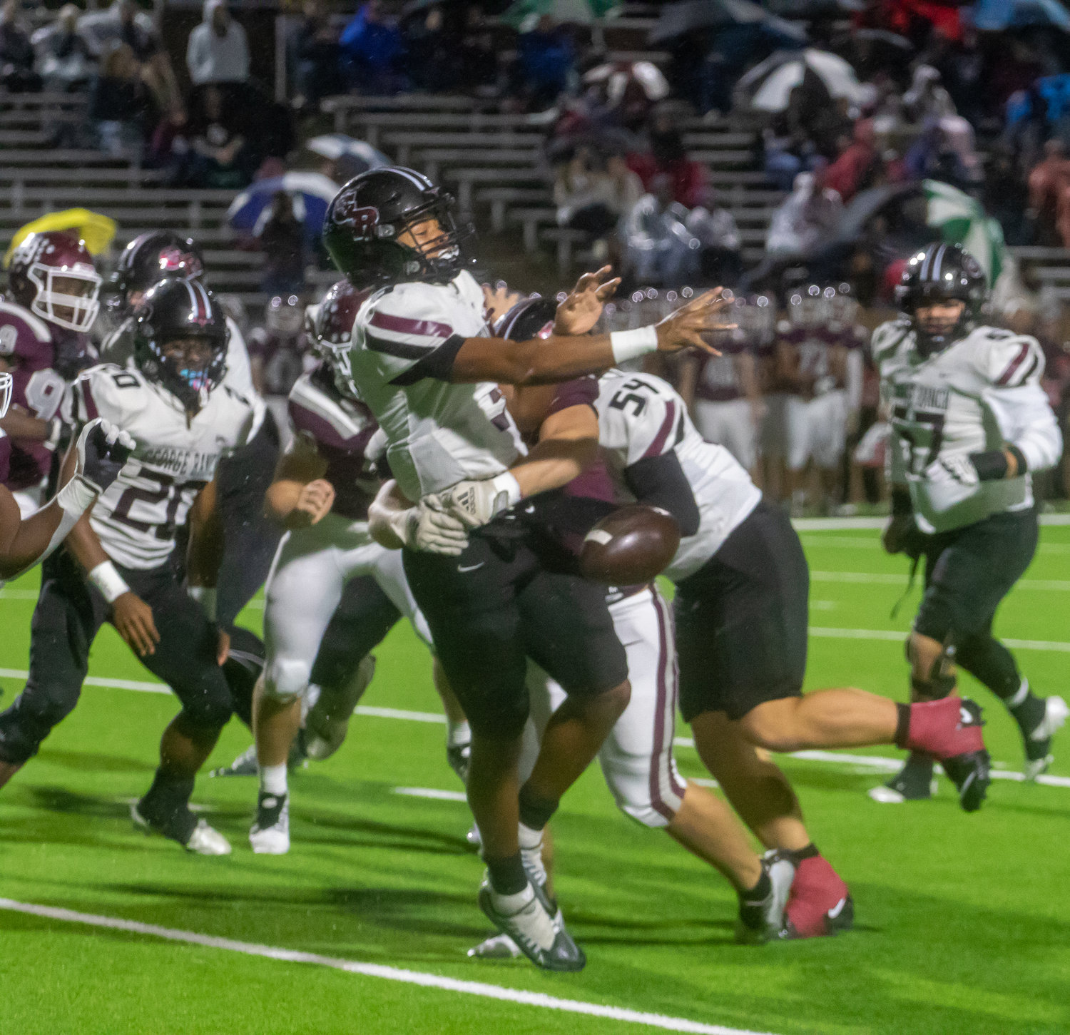Cinco Ranch's defense forces a fumble during Friday's game between Cinco Ranch and George Ranch at Rhodes Stadium.