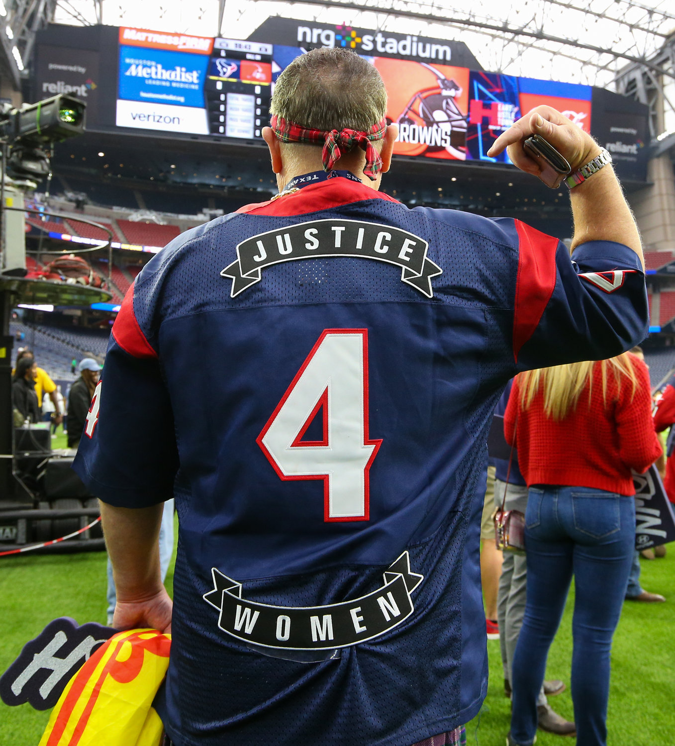 A Houston Texans fan wears Deshaun Watson’s former Texans #4 jersey with the slogan “Justice 4 Women” on the sideline ahead of an NFL game between the Texans and the Browns on Dec. 4, 2022, in Houston. The game marks the controversial quarterback’s return to Houston and first game back after an 11-game suspension for allegations of sexual misconduct during his tenure with the Texans.