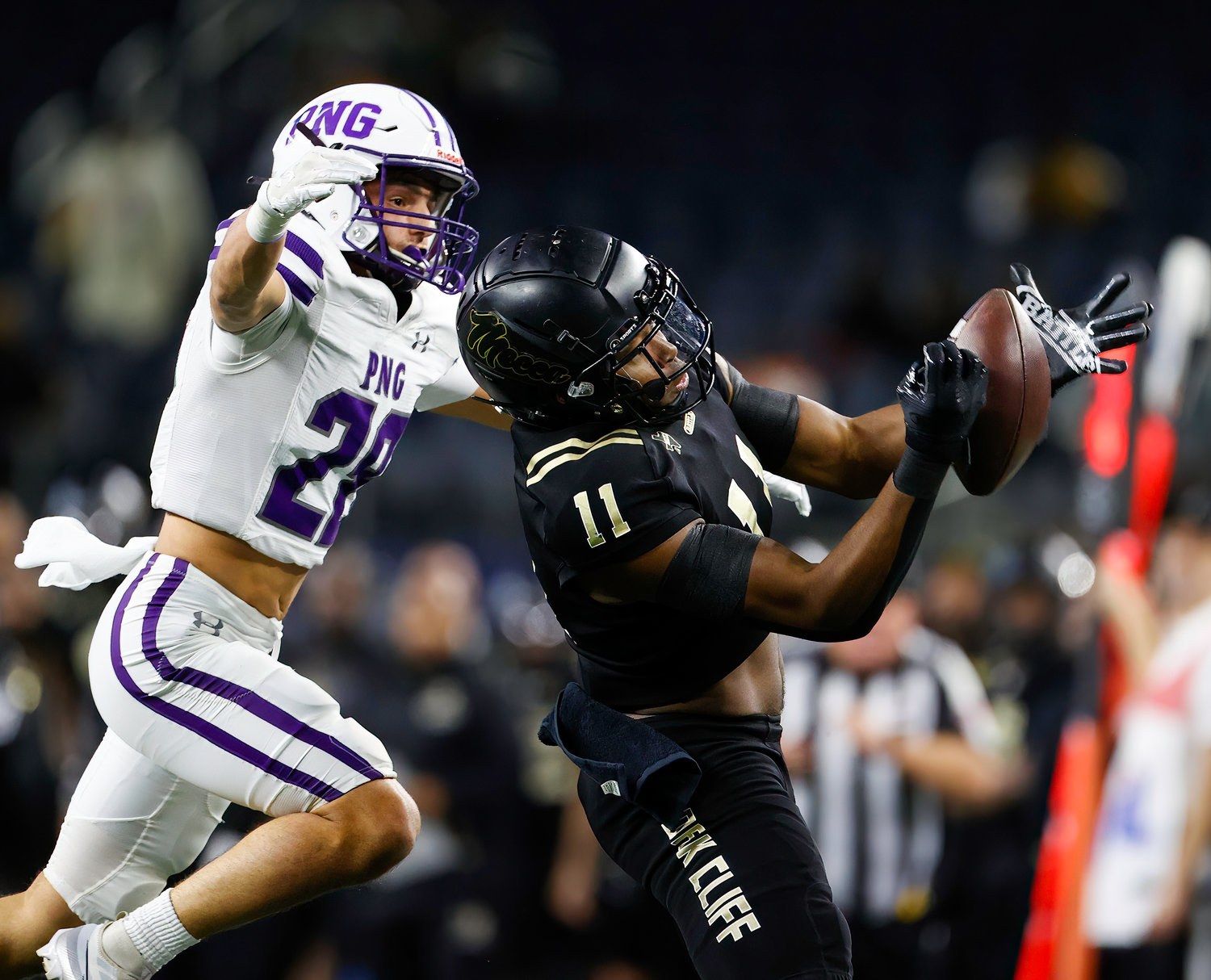 South Oak Cliff wide receiver Jamyri Cauley (11) makes a catch for a first down over Port Neches-Groves defensive back Reid Richard (28) during the Class 5A Division II football state championship game between South Oak Cliff and Port Neches-Groves in Arlington, Texas, on Dec. 16, 2022.
