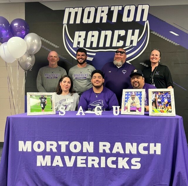 Morton Ranch's Adrian Covarrubias poses for a photo after singing their National Letters of Intent.