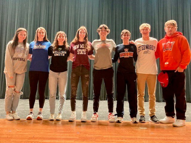 Seven Lakes Miguel Acosta, Taylor Craft, Grace Havern, Lainey Hieser, Hunter Merrit, Reese Sullivan, Josh Vetter and Emma Wingate pose for a photo after singing their National Letters of Intent.