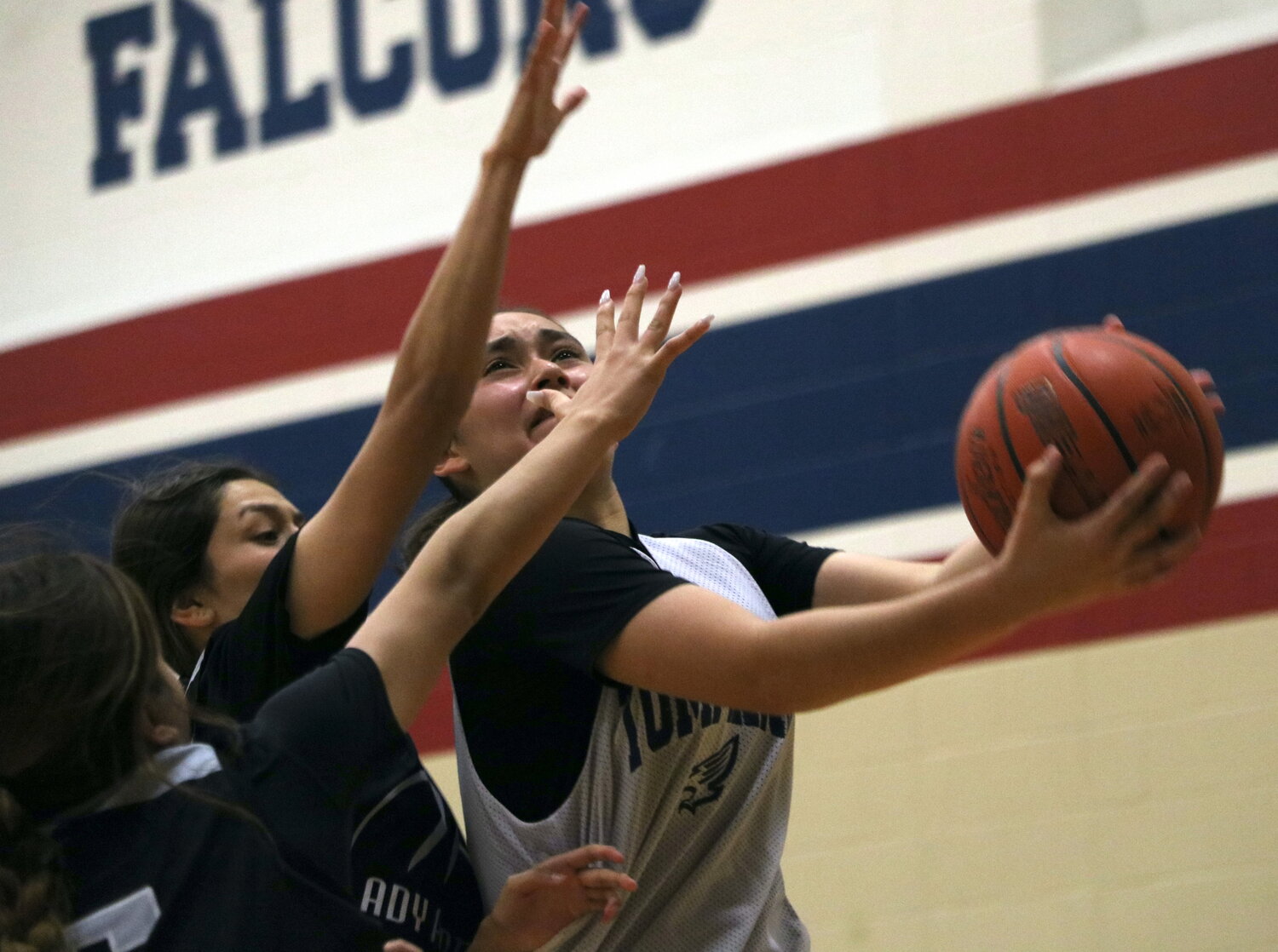 Rihanna DeLeon shoots a layup over two Laredo United South defenders during Thursday's game between Tompkins and Laredo United South defenders at the Tompkins gym.