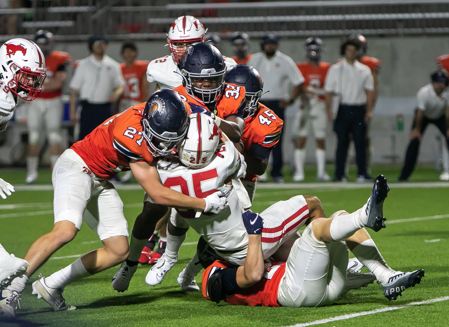 Seven Lakes players bring down Memorial's Cooper Gindorf during Thursday's game between Seven Lakes and Memorial at Legacy Stadium.