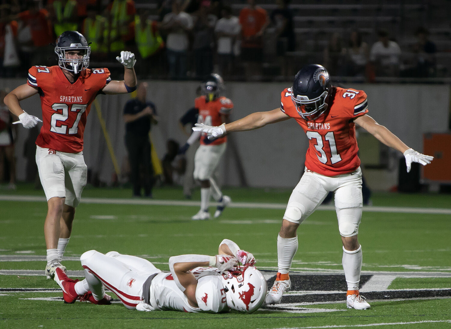 Carter LeCompte and John Paul Johnson celebrate after a pass breakup during Thursday's game between Seven Lakes and Memorial at Legacy Stadium.