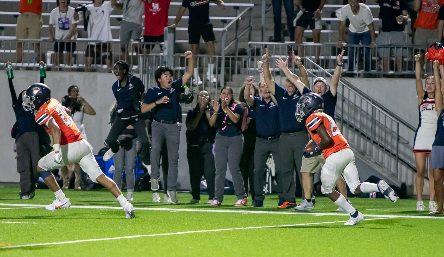 Seven Lakes' sideline celebrates after Keaton Fowler-Smith intercepted a pass in overtime during Thursday's game between Seven Lakes and Memorial at Legacy Stadium.