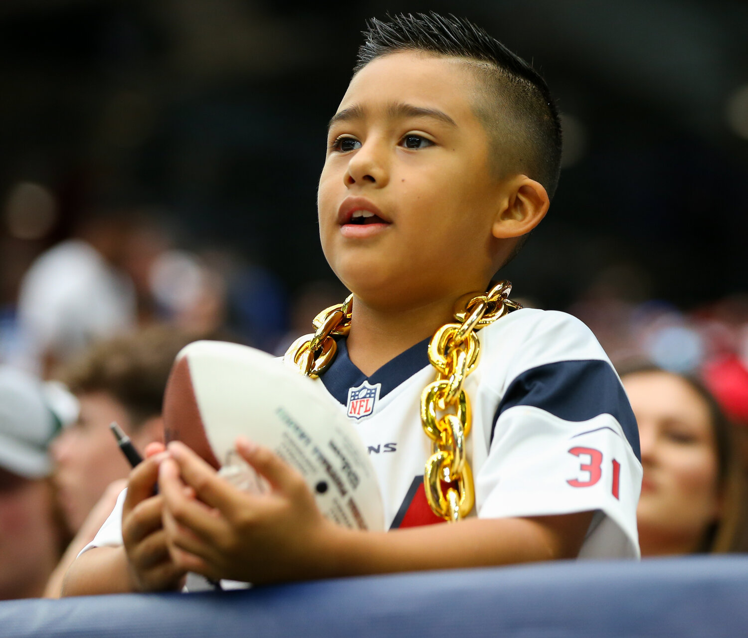 A young Houston Texans fan sits in the stands waiting for autograph opportunities during an NFL game between the Texans and the Colts on September 17, 2023 in Houston. The Colts won, 31-20.