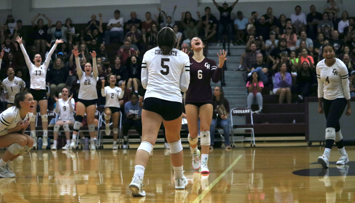Cinco Ranch players celebrate after winning a set during Tuesday’s match between Cinco ranch and Seven Lakes at the Cinco Ranch gym.