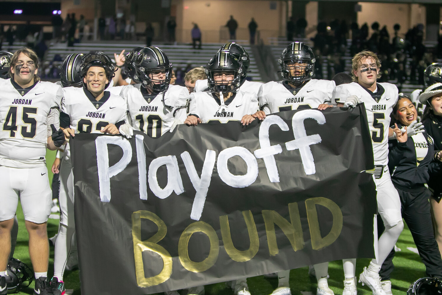 Jordan lifts a playoff banner after its game against Morton Ranch on Thursday at Legacy Stadium..