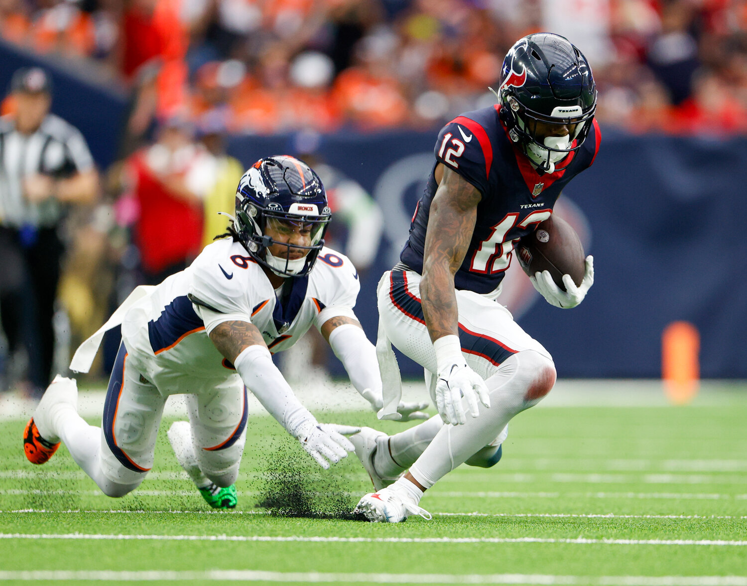 Broncos safety P.J. Locke (6) pushes Texans wide receiver Nico Collins (12) down for a tackle after a catch during an NFL game between the Texans and the Broncos on December 3, 2023 in Houston. The Texans won, 22-17.