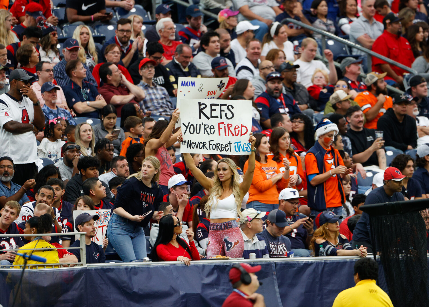 A Houston fan holds up a sign stating “Refs: You’re Fired” during an NFL game between the Texans and the Broncos on December 3, 2023 in Houston. The Texans won, 22-17.