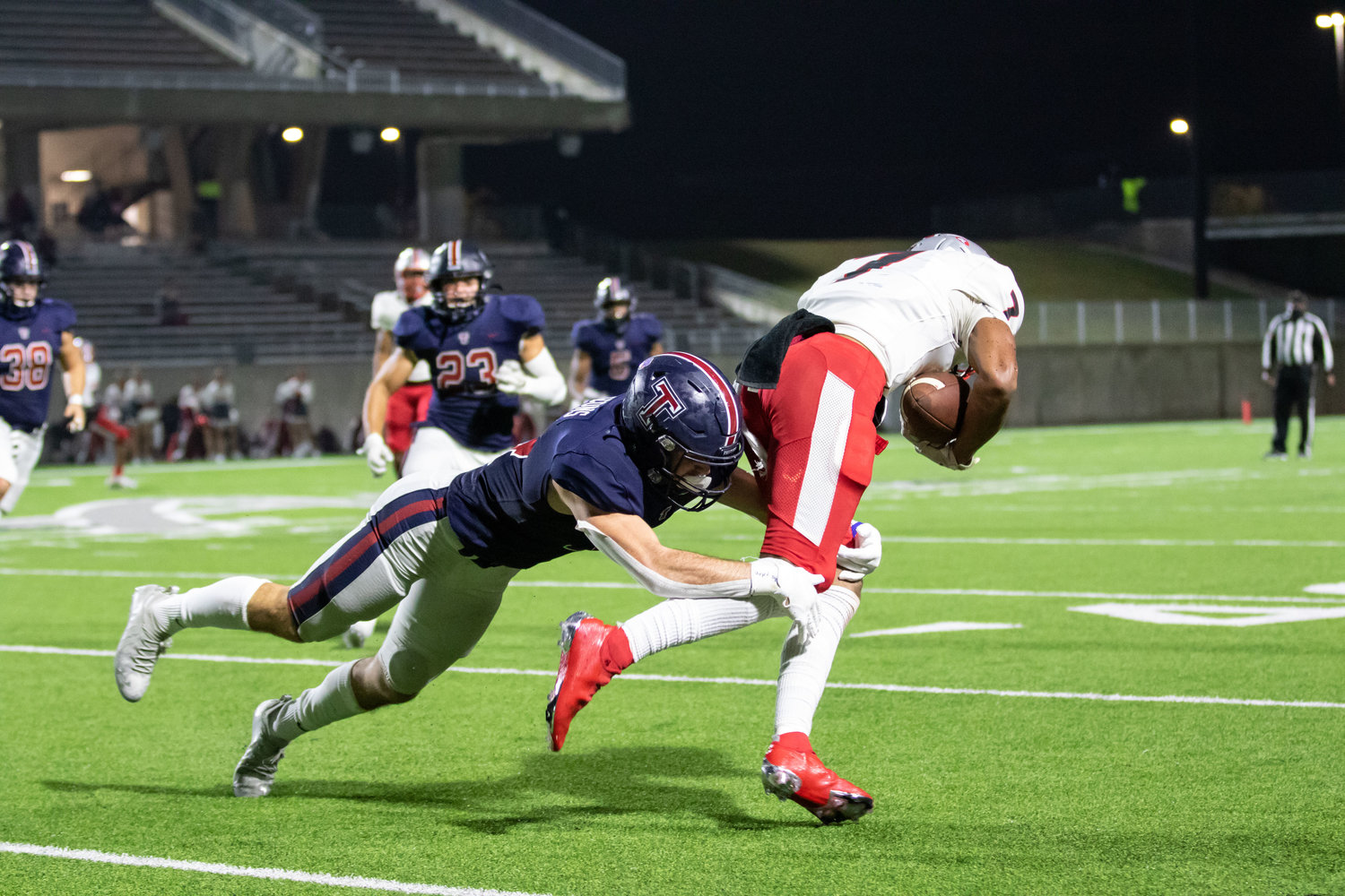 Tompkins senior safety Colby Huerter brings down Travis receiver Cameron Moore during the Falcons' 42-10 Class 6A Division I bi-district playoff win over Fort Bend Travis on Dec. 11 at Legacy Stadium.
