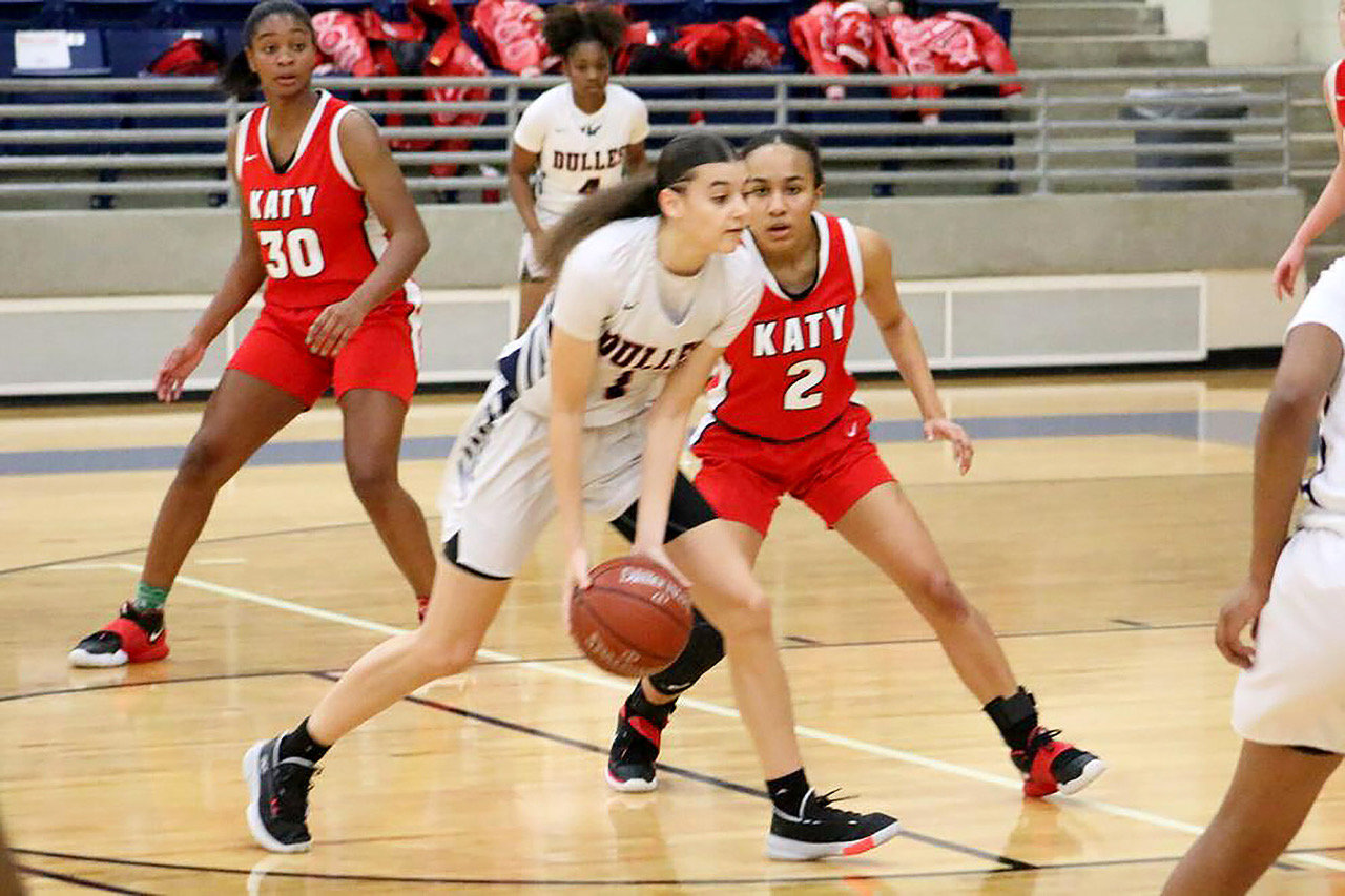 Dulles junior guard Dai Dai Powell moves the ball as she is guarded by Katy senior guard Amber Bourgeois in Thursday's 6A bi-district playoff game at Hopson Field House.