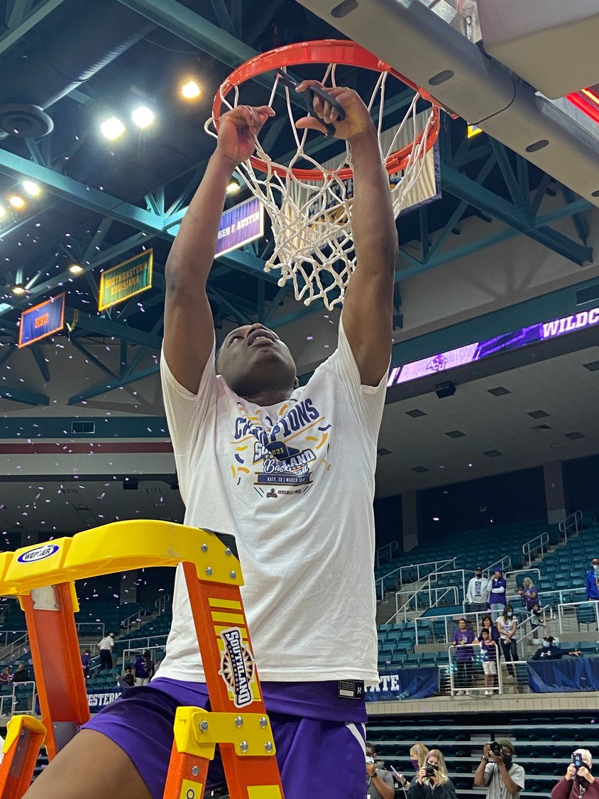 Abilene Christian senior guard and Southland Conference Tournament Most Valuable Player Damien Daniels cuts a piece of the net in celebration after the Wildcats beat Nicholls, 79-45, to win the tournament for the second straight season on Saturday, March 13, at the Merrell Center.