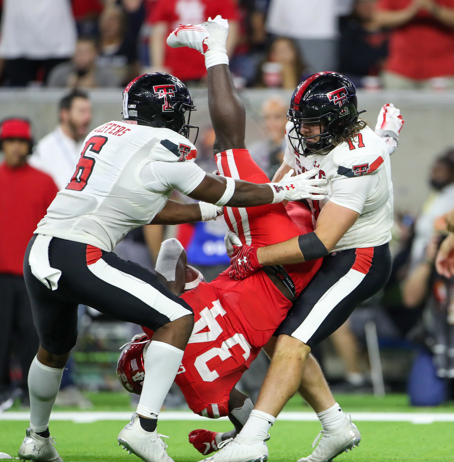 Houston Cougars running back Mulbah Car (34) is upended in the backfield by Texas Tech Red Raiders linebacker Colin Schooler (17) during an NCAA football game between Houston and Texas Tech on September 4, 2021 in Houston, Texas.