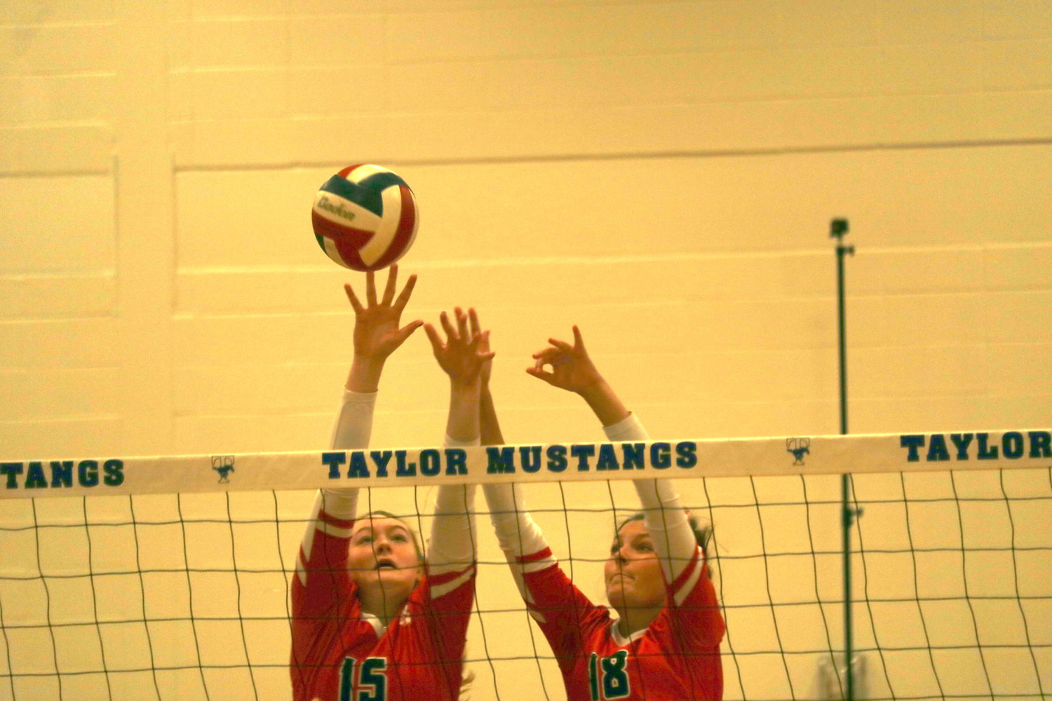 Jordan Gamble and Addison Chapman try to block a ball during during a District 19-6A match between Katy and Taylor at the Taylor gym.