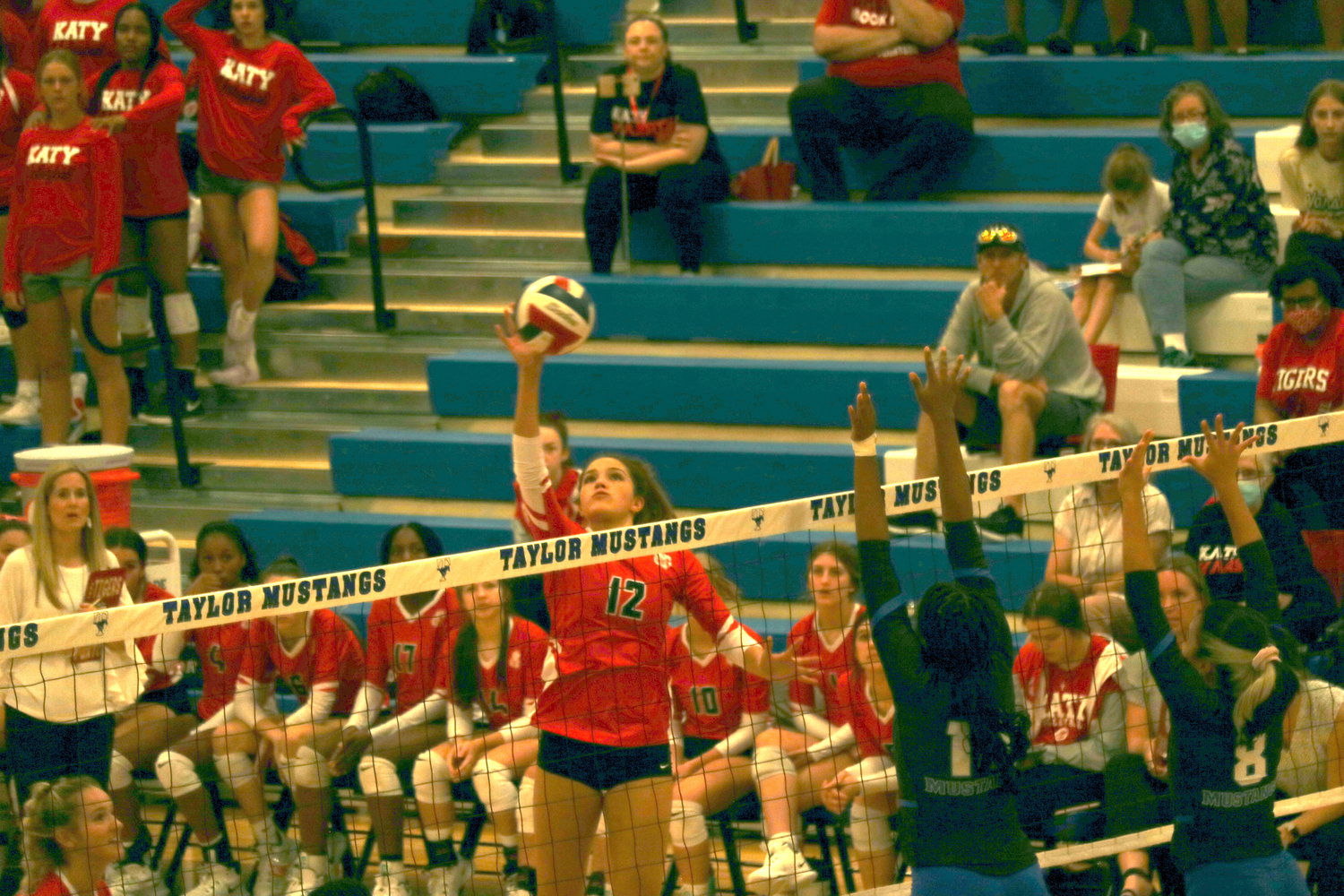 Nyla Wold tries to tip the ball over the net during a District 19-6A match between Katy and Taylor at the Taylor gym.