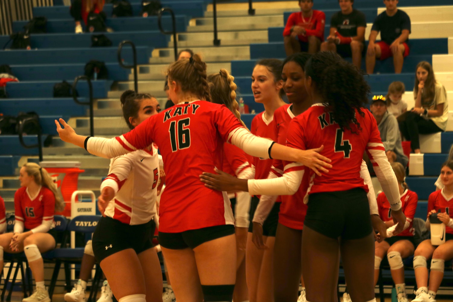 Katy players huddle together after a point during a District 19-6A match against Taylor at the Taylor gym.