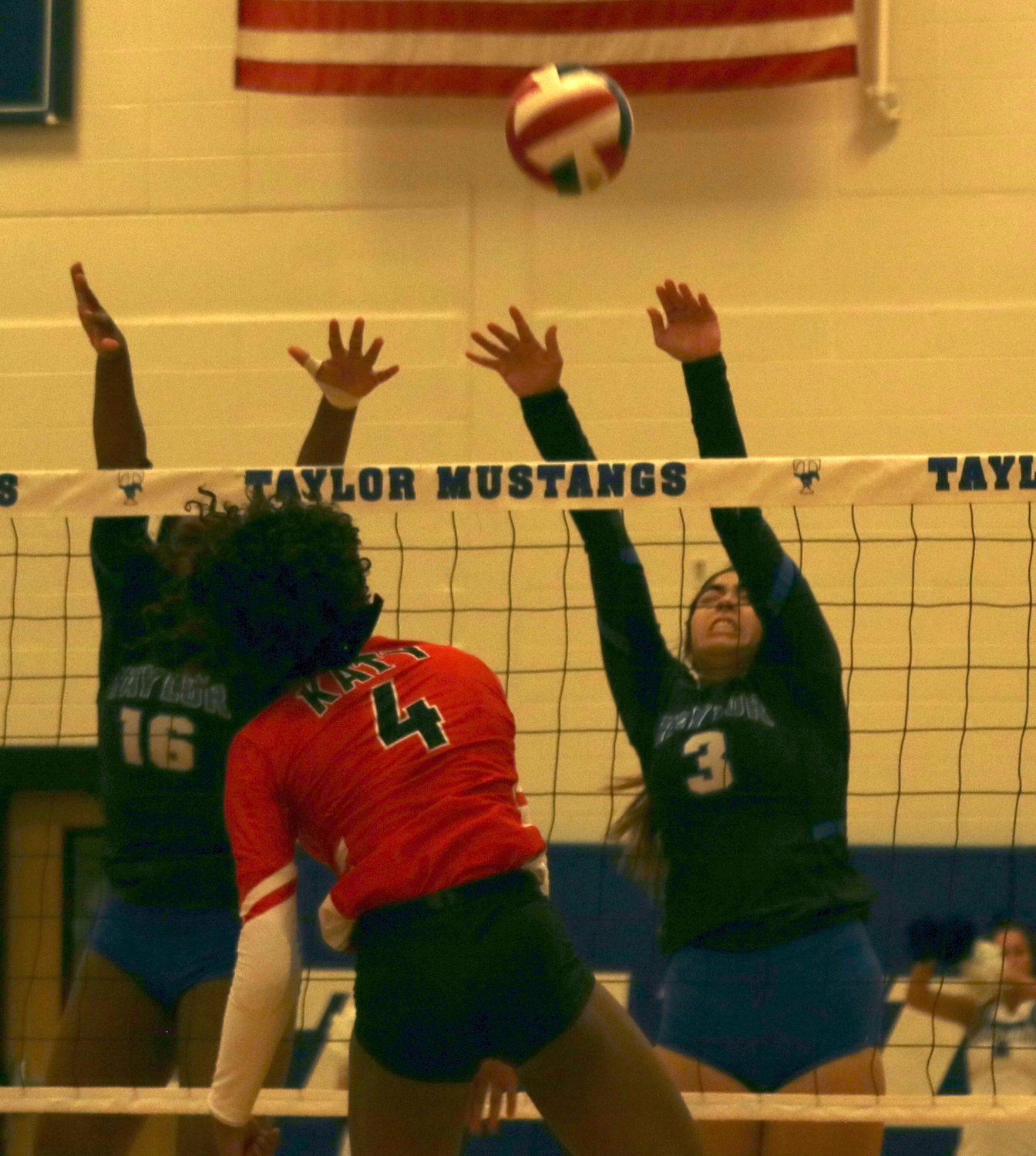 An attack from Chandler Lee sails over the head’s of Nicole Carrasco and Bria Dixon during a District 19-6A match between Katy and Taylor at the Taylor gym.