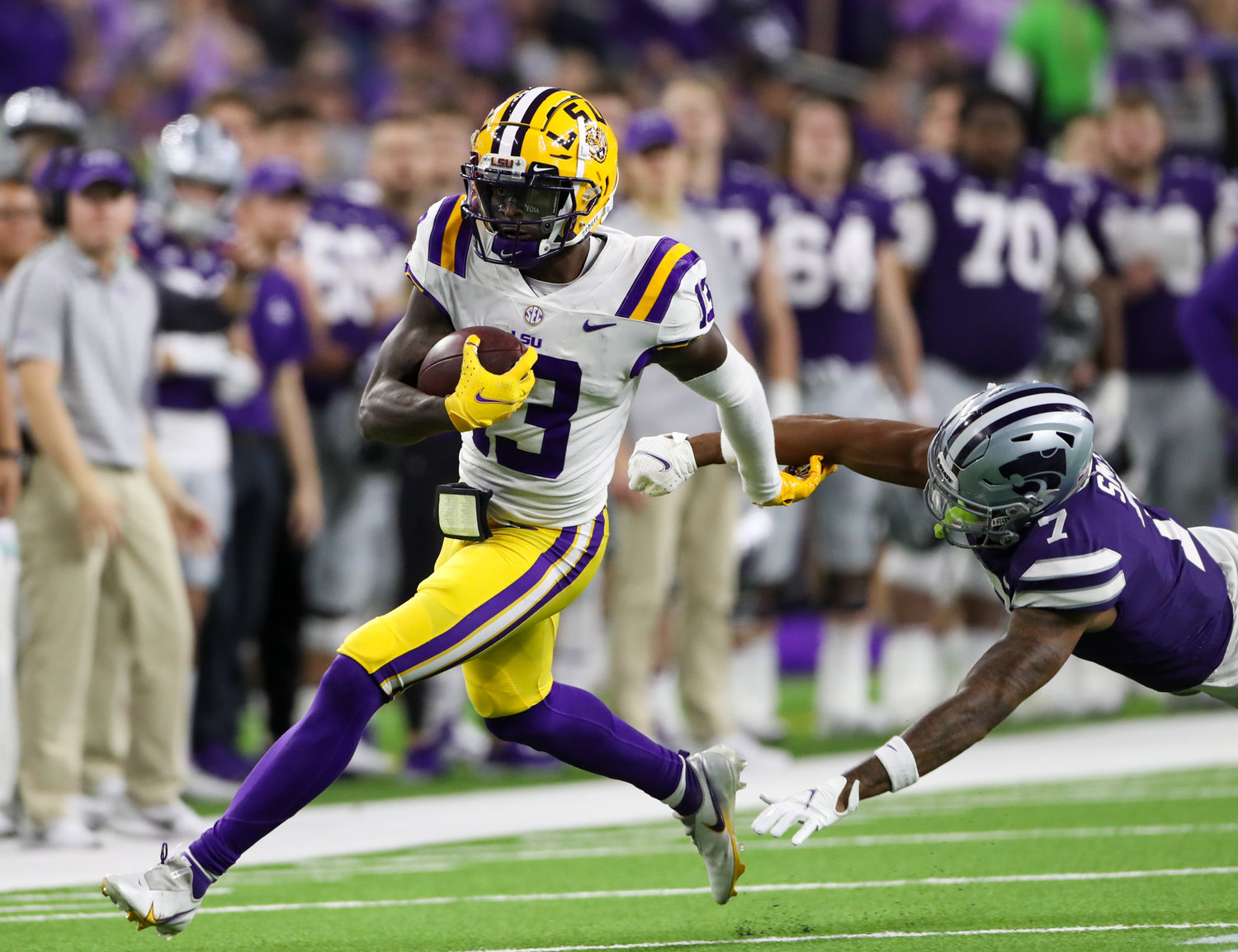 LSU Tigers quarterback Jontre Kirklin (13) escapes the grasp of Kansas State Wildcats defensive back TJ Smith (7) on a first-down carry during the first half of the TaxAct Texas Bowl on Jan. 4, 2022 in Houston, Texas.