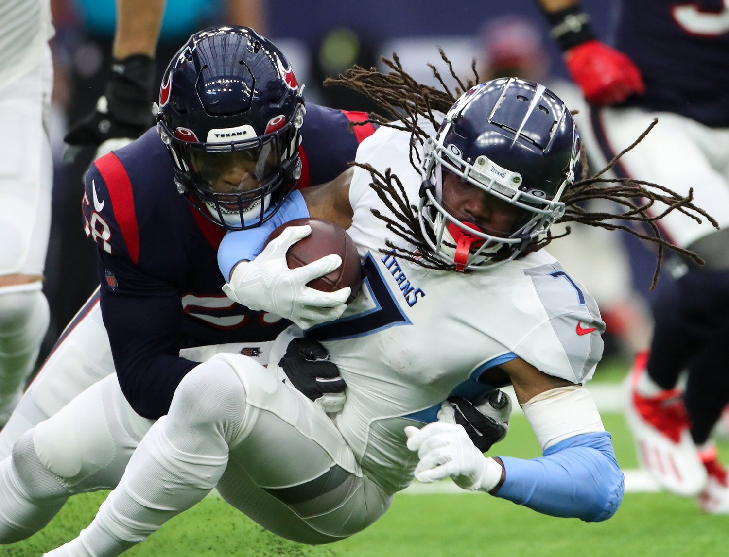 Tennessee Titans running back D'Onta Foreman (7) is tackled by Houston Texans middle linebacker Christian Kirksey (58) during an NFL game between the Texans and the Titans on Jan. 9, 2022 in Houston, Texas.