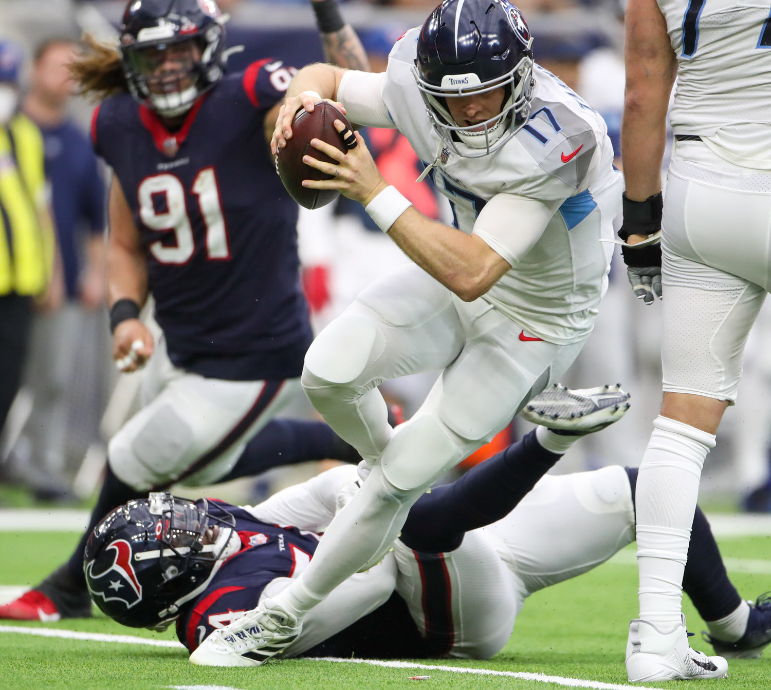 Tennessee Titans quarterback Ryan Tannehill (17) escapes a would-be sack by Houston Texans defensive end Jacob Martin (54) during an NFL game on Jan. 9, 2022 in Houston, Texas. The Titans won, 28-25.