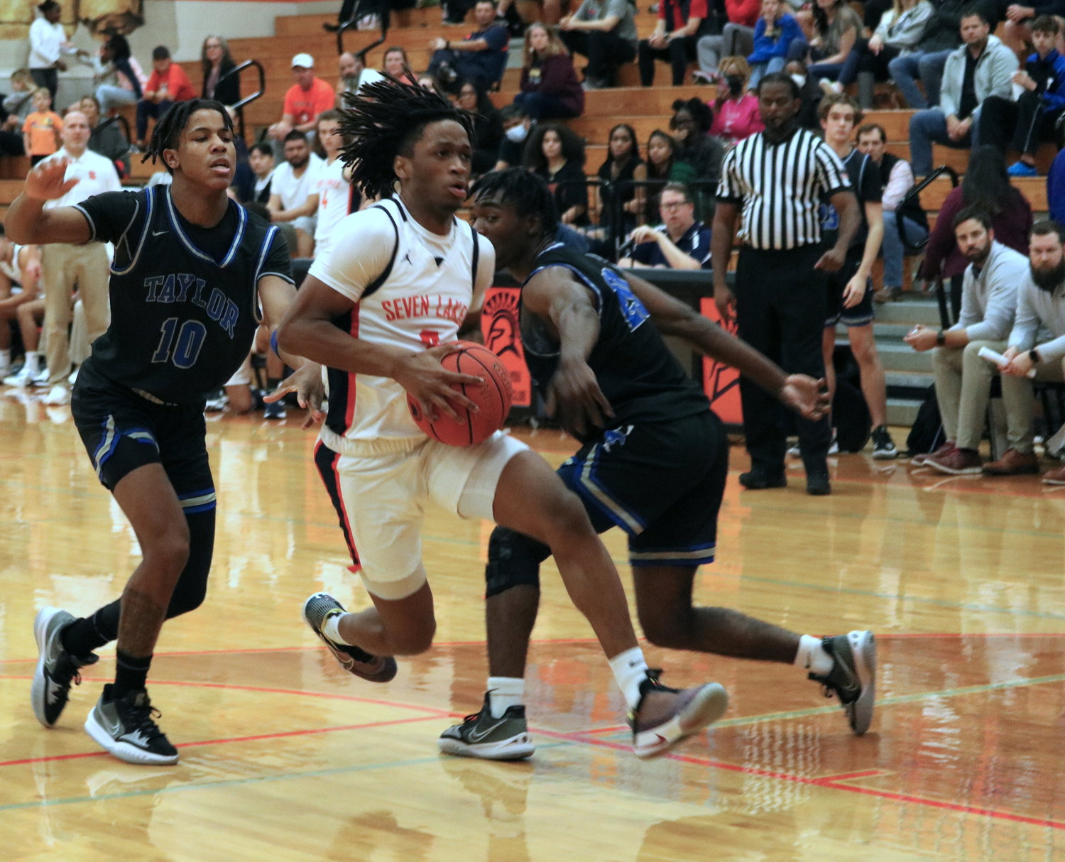 Tahaad Davis drives through the lane during Wednesday’s game between Seven Lakes and Taylor at the Seven Lakes gym.