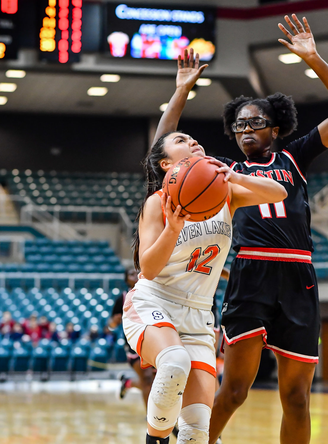 Katy Tx. Feb 22, 2022:  Seven Lakes Cailyn Tucker #12 drives to the basket scoring for the Spartans during the Regional Quarterfinal playoff game, Seven Lakes vs Fort Bend Austin at the Merrell Center. (Photo by Mark Goodman / Katy Times)